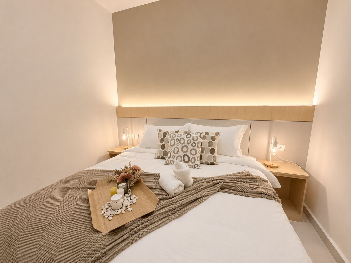 Een hotelkamer met een groot bed, twee nachtkastjes, een hoofdeinde en een bedlampje.