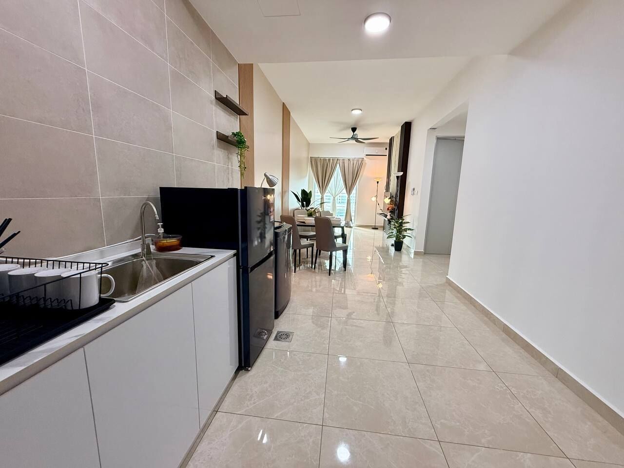 A modern kitchen with a dining area, a ceiling fan, and a view of the city.