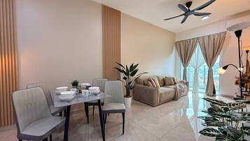 A modern living room with a dining area, a sofa, and a ceiling fan.