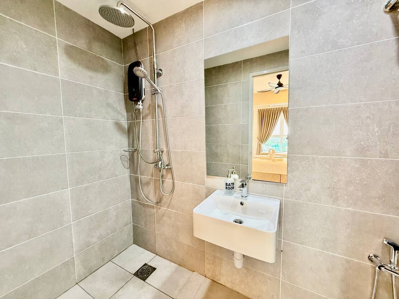 A bathroom with a shower, a sink, and a mirror.