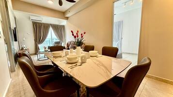 A modern dining area with a marble table, brown upholstered chairs, and a ceiling fan.