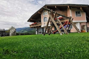 A chalet with a wooden deck, a slide, and a mountain view. - Apartment Mary (4-8 people) (Fürth)