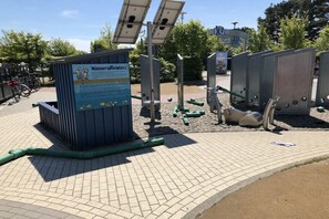 Eine Wasserstation mit Solarstrom, einem Schild, Solarmodulen und Wasserspendern.