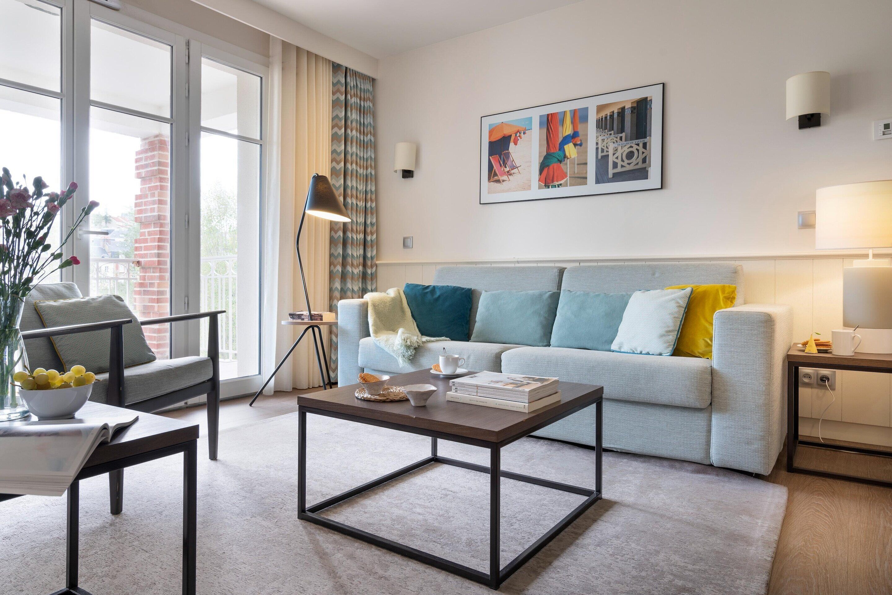 A modern living room with a sofa, coffee table, and a lamp.