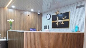 Un comptoir d’accueil avec un revêtement en bois, une horloge et une œuvre d’art encadrée accrochée au mur.