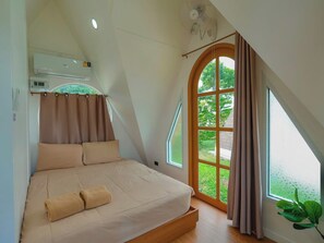 A bedroom with a bed, a window, and a ceiling fan.