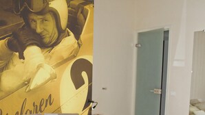 Un dormitorio con una cama grande, una puerta, una mesita y una pared decorada con un gráfico.