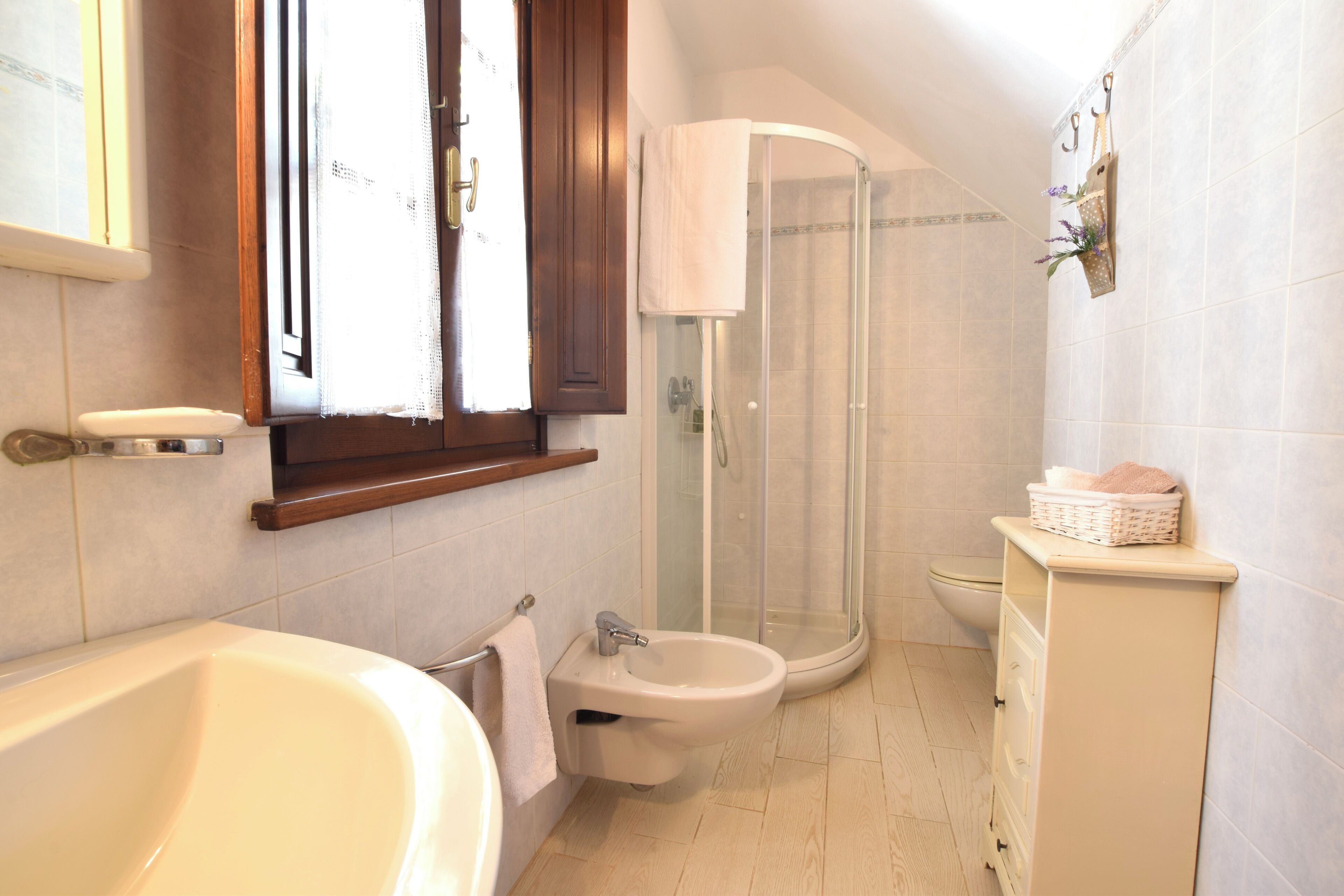 Une salle de bain équipée d’une baignoire, d’un bidet, de toilettes et d’un espace douche.