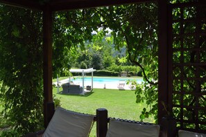 A covered outdoor area with a pool, lounge chairs, and a pergola. - Wonderful villa with private pool in the first hills of Camaiore (Toscana)