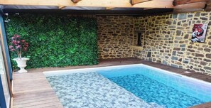 A swimming pool with a stone wall and a green hedge. - Country charm and character + Swimming pool (Tinténiac)
