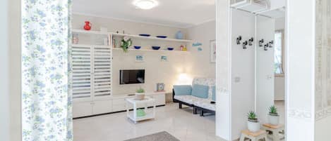 Un salón con sofá, mesa de centro y estanterías con adornos.