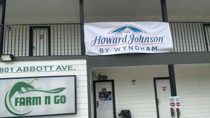 Um edifício com uma placa indicando Howard Johnson by Wyndham e o logotipo Farm n Go.