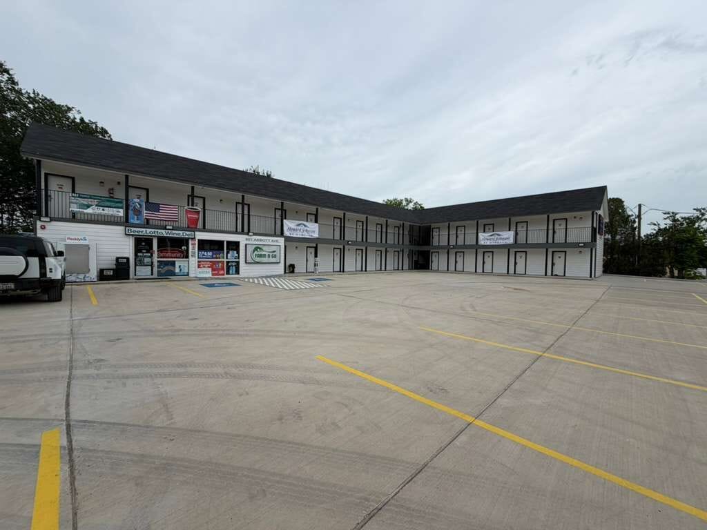 Un grand immeuble comprenant plusieurs logements, un parking et un camion.