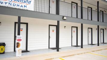 A hotel with a row of rooms, each with a door and a 'No Smoking' sign. A banner for 'Card Johnson' is displayed above the entrance.