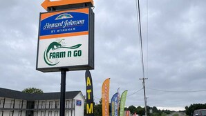 Placa da Howard Johnson by Wyndham, um caixa eletrônico e uma loja Farm n Go.