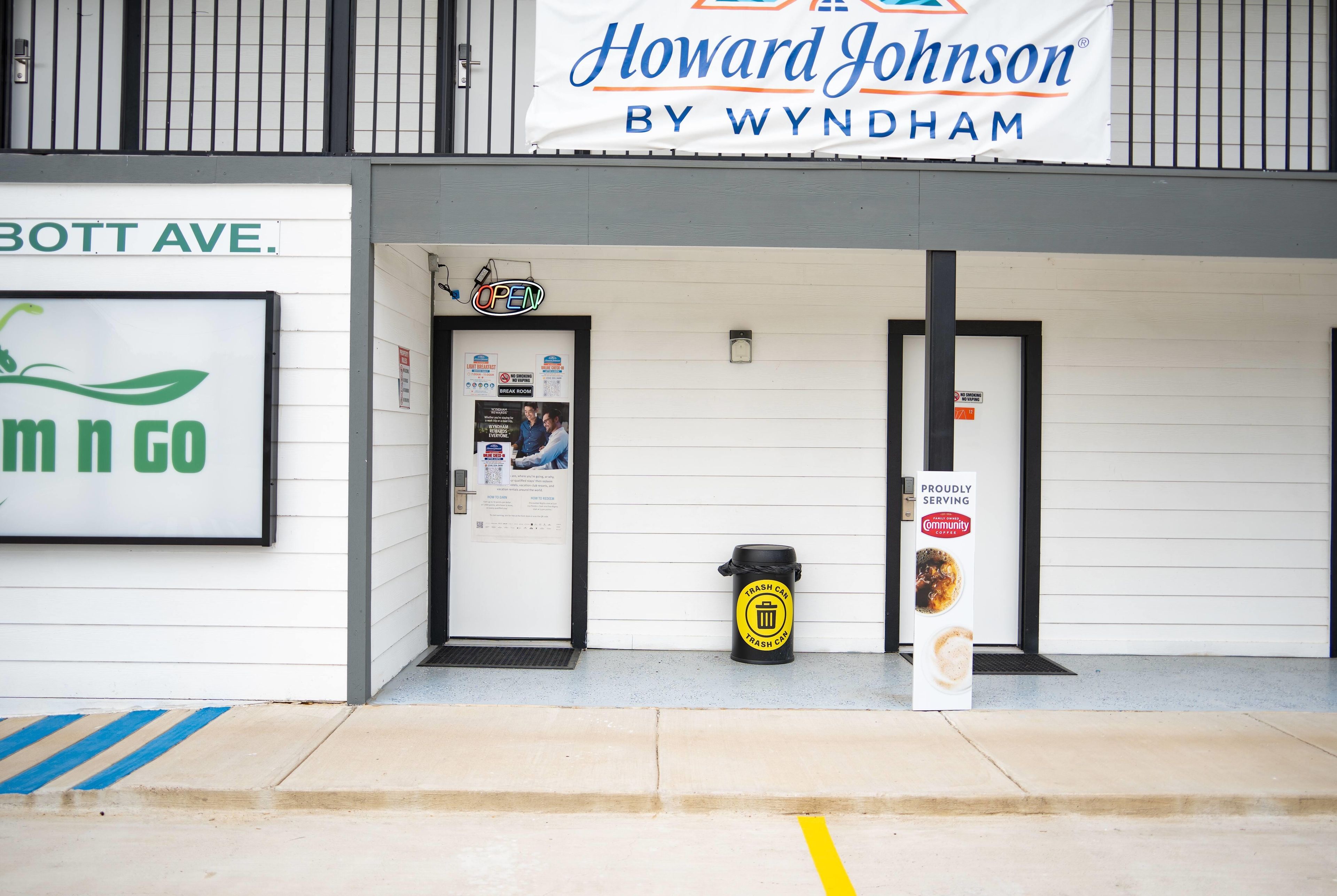 Fachada con letrero de Howard Johnson by Wyndham, un basurero y un cartel de prohibido fumar.