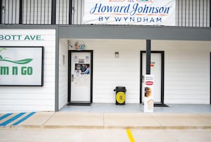 Fachada con letrero de Howard Johnson by Wyndham, un basurero y un cartel de prohibido fumar.