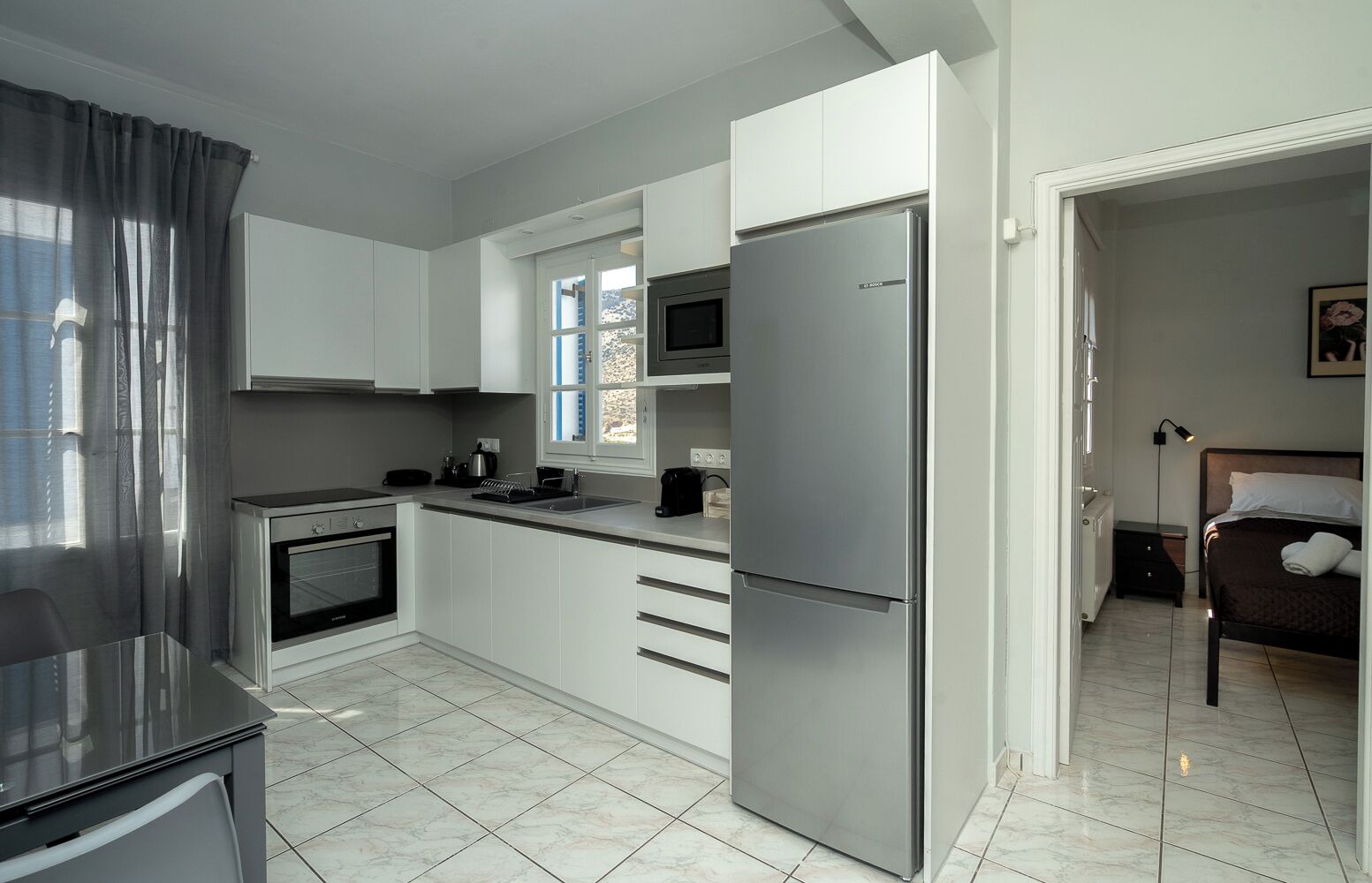 A modern kitchen with a built-in oven, a refrigerator, and a microwave.
