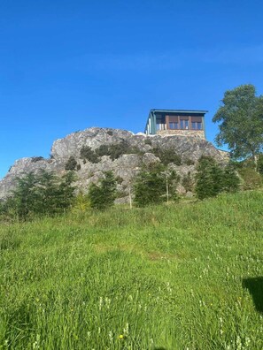 Un edifici sobre un turó rocós sota un cel serè.