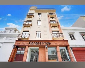 Un edificio de varios pisos con un cartel que dice 'Ganges Pride' al nivel de la calle.