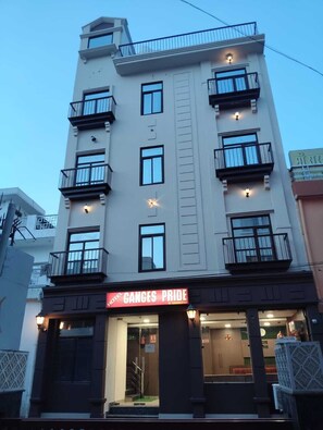 A multi-story hotel with balconies, a prominent sign reading 'GANGES PRIDE,' and a visible entrance.