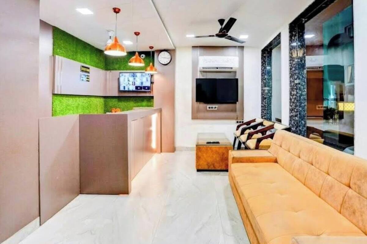 Un salon moderne avec un canapé, un téléviseur et un ventilateur de plafond.