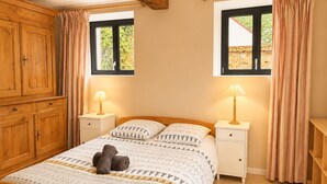 A bedroom with a wooden bed, two bedside tables, a wardrobe, and two windows with curtains. - Charming country house in a flower garden between Paris and Chartres (Yermenonville)