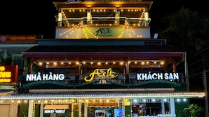 Un restaurante con un letrero que dice 'AnBua' y 'KHACCH SAN' por la noche.