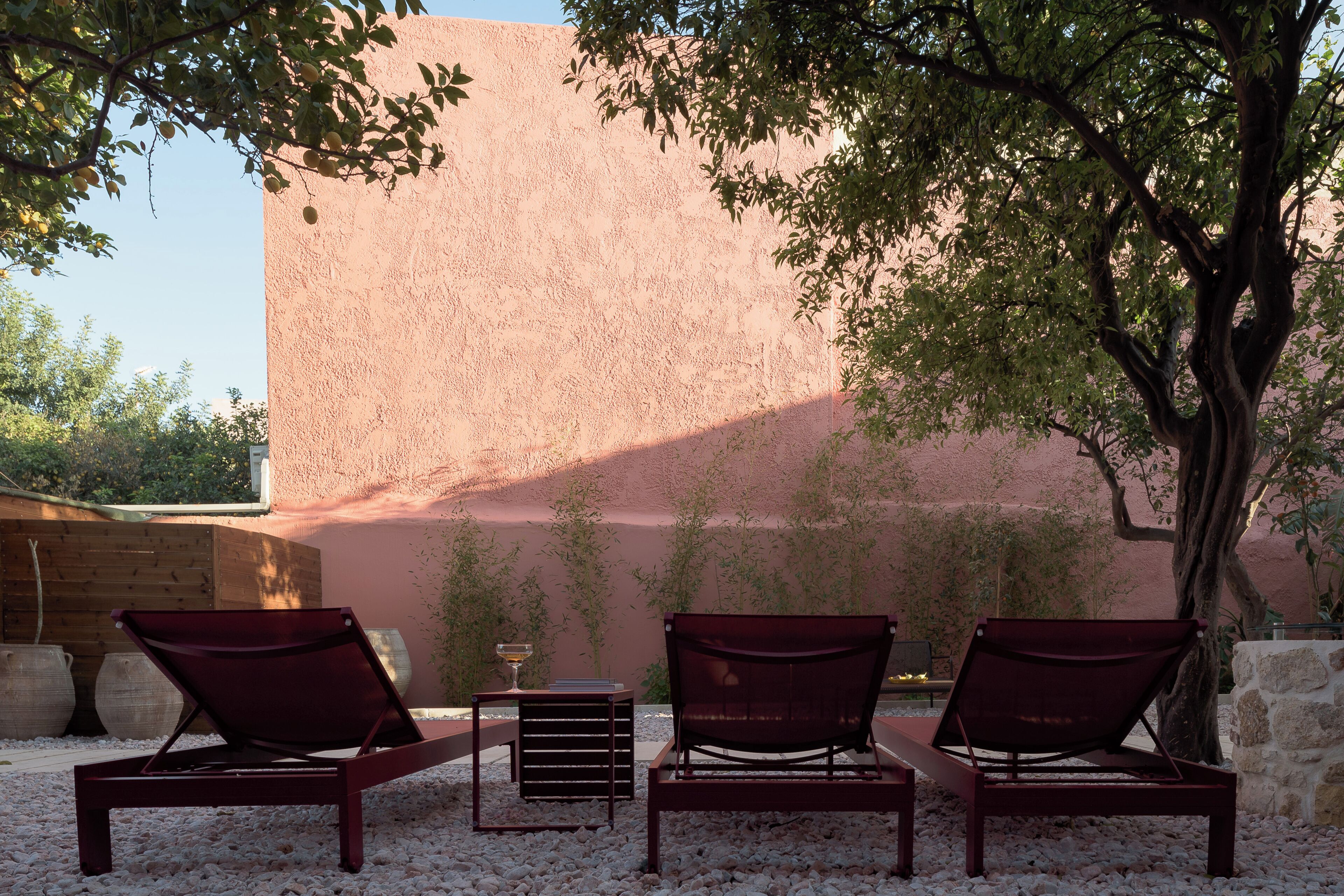 A seating area with three lounge chairs, a small table, and a potted plant.