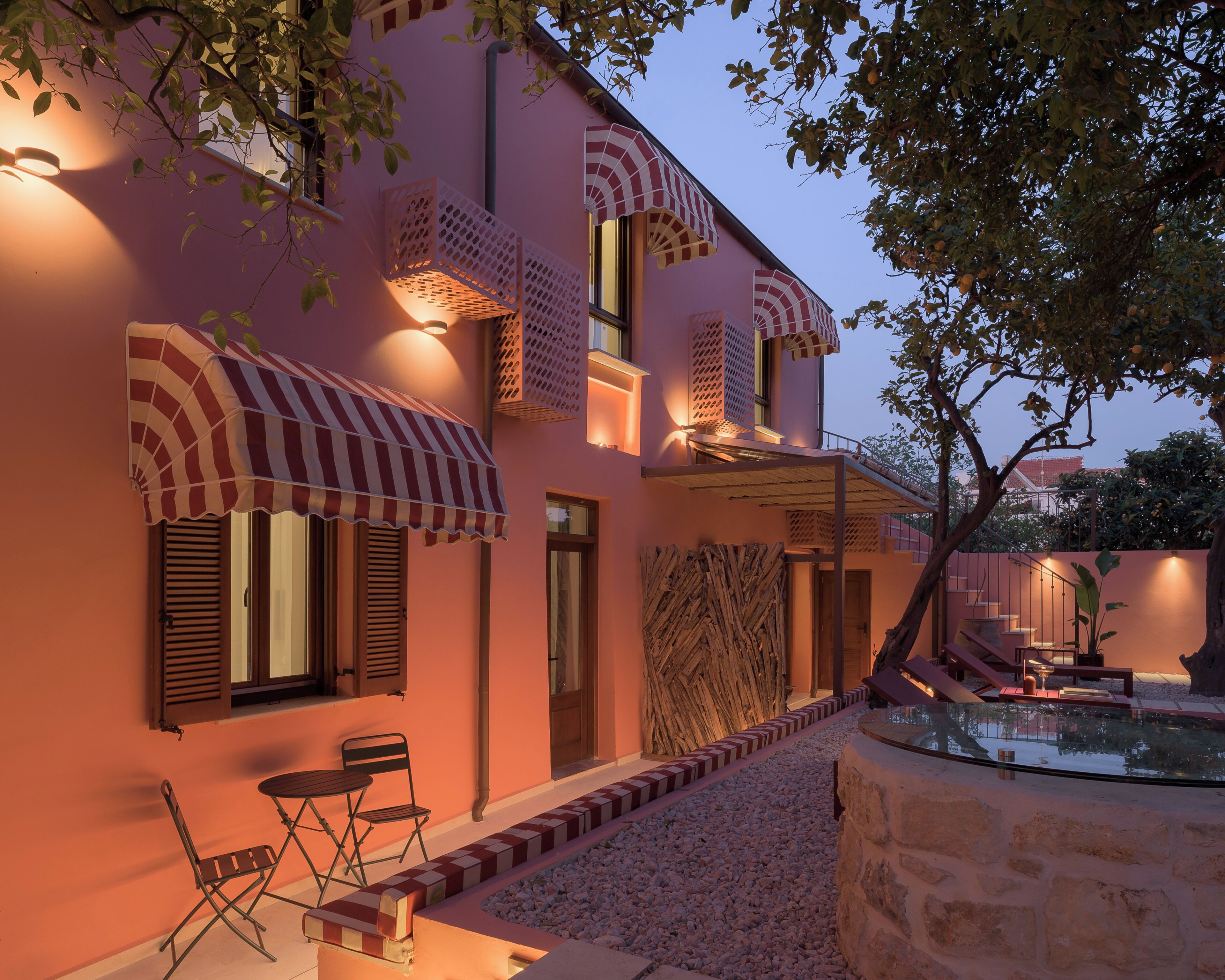 A building with multiple balconies, outdoor seating, and a small pool area.