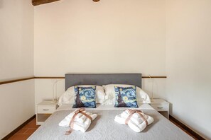 A hotel room with a bed, two bedside tables, and a nightstand.