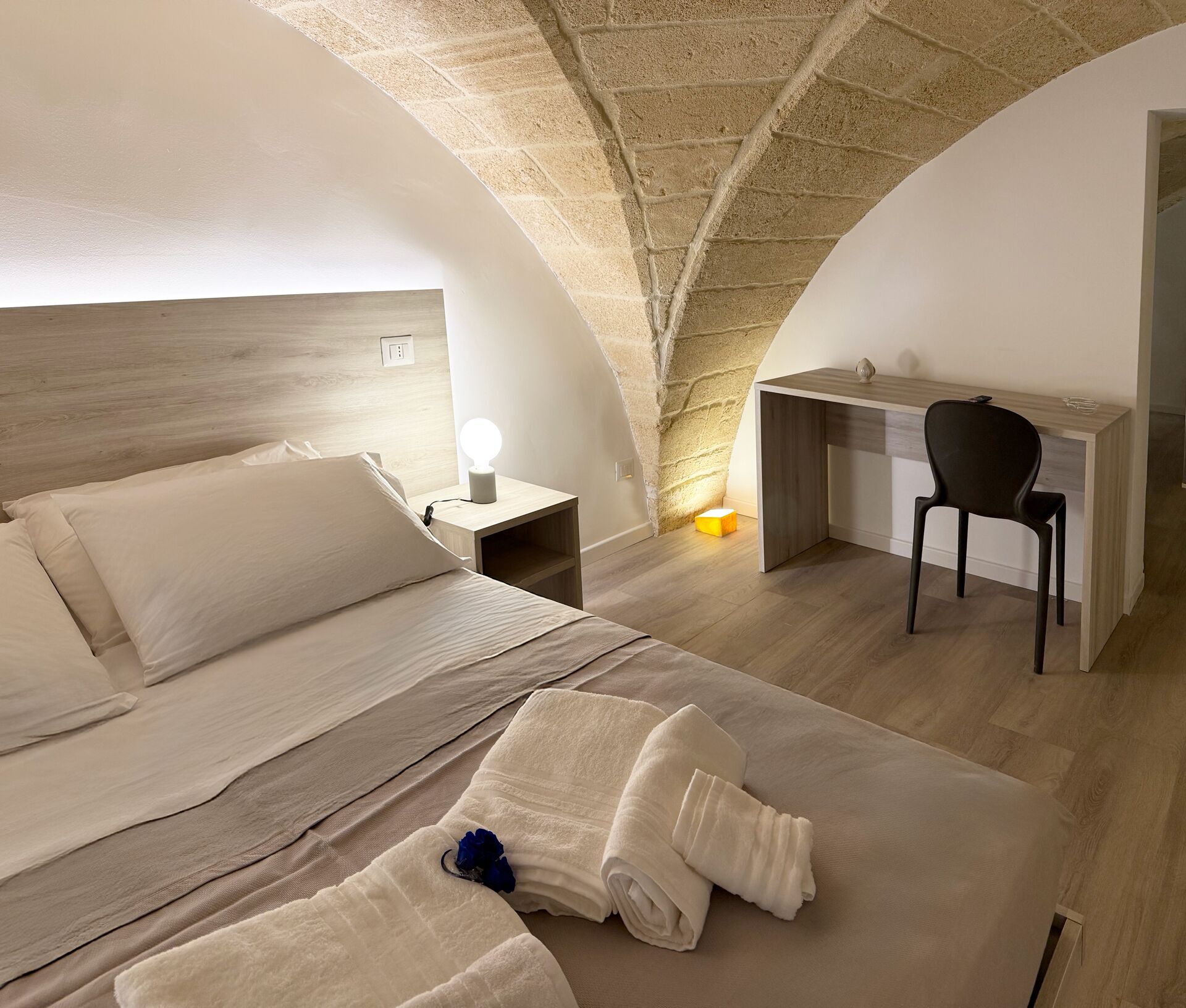 A bedroom with a bed, a desk, and a chair.
