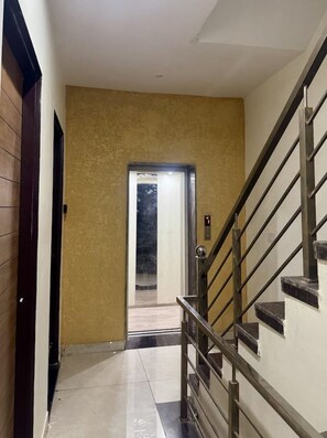 Ein Flur mit Treppe, einer Tür zu einem anderen Raum und einer strukturierten Wand.