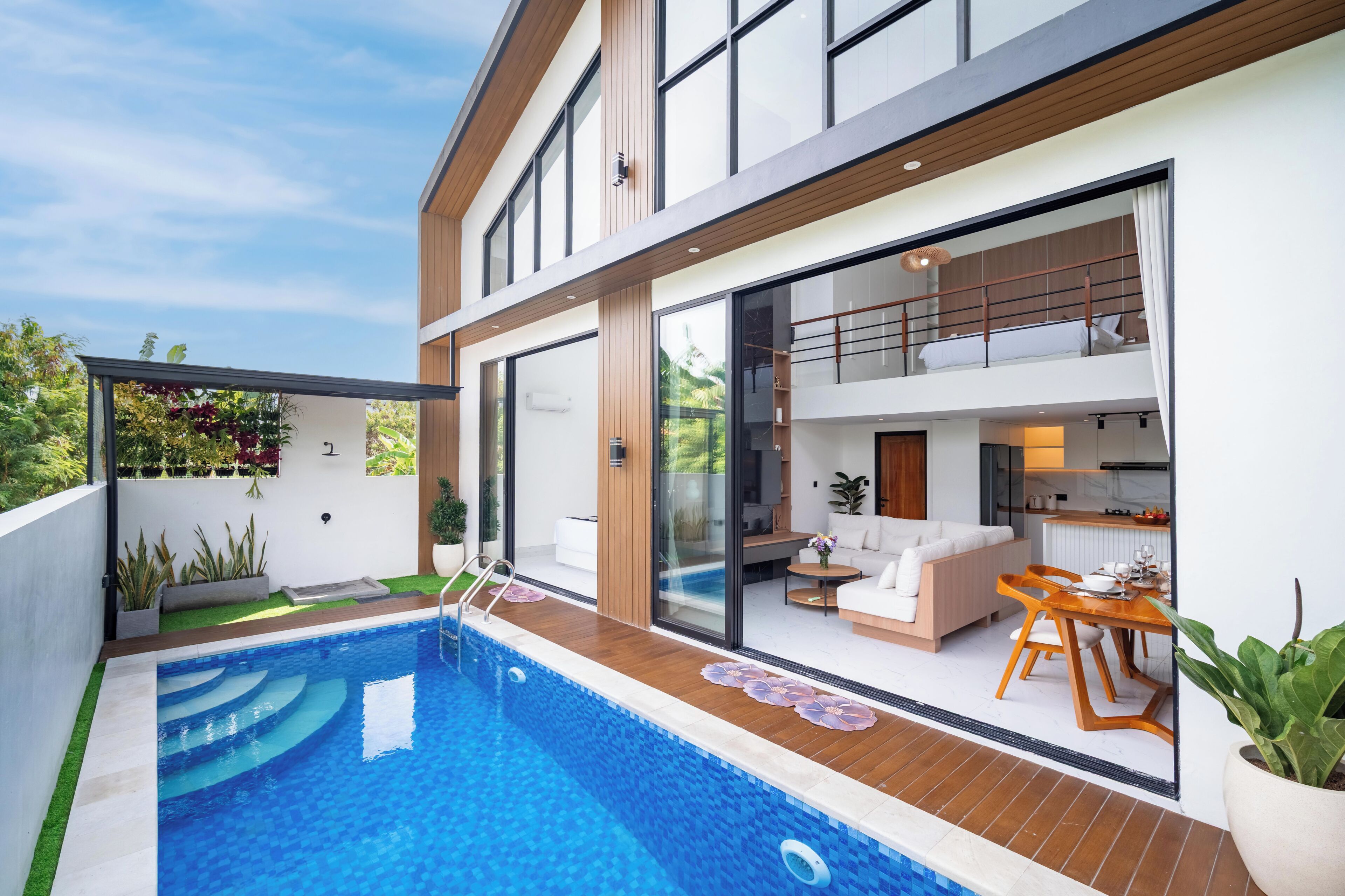 Une maison moderne dotée d’une piscine, d’un balcon et d’un coin repas.