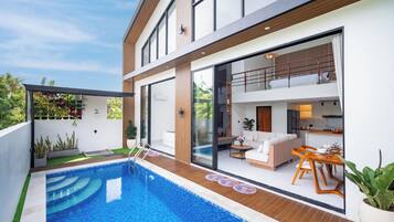 Une maison moderne dotée d’une piscine, d’un balcon et d’un coin repas.