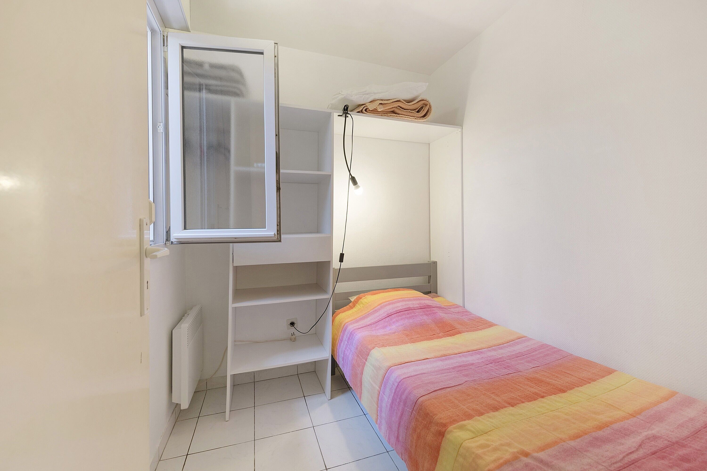 Een slaapkamer met een stapelbed, een kledingkast en een radiator.