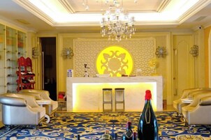 Un vestíbulo de hotel con mostrador de recepción, zona de estar y un candelabro.