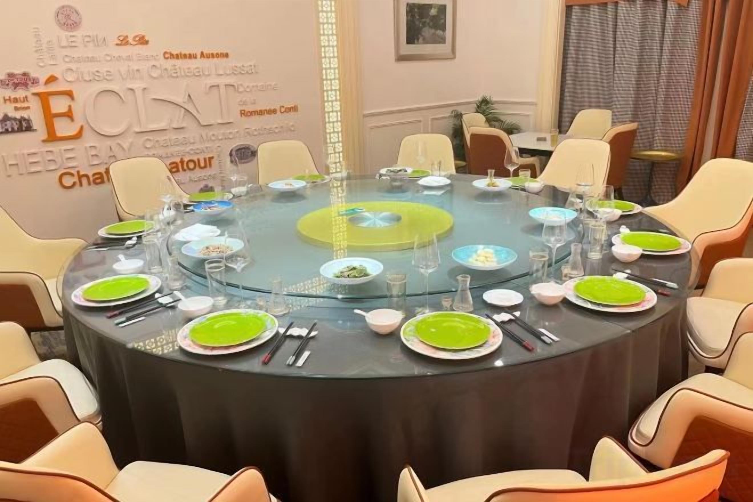 Una mesa redonda dispuesta para una comida, con sillas alrededor.