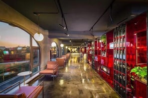 Un interior moderno con un largo pasillo, zonas de estar y vistas amplias a través de grandes ventanales.