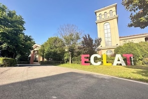 Un edificio con un cartel grande que dice 'ECLAT' frente a un camino pavimentado.
