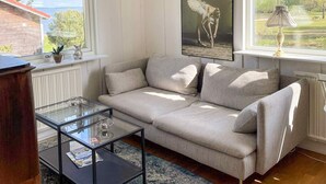 A living room with a sofa, a glass coffee table, and a painting on the wall. - 5 Star Holiday Home in Vingaker (Vingåker)