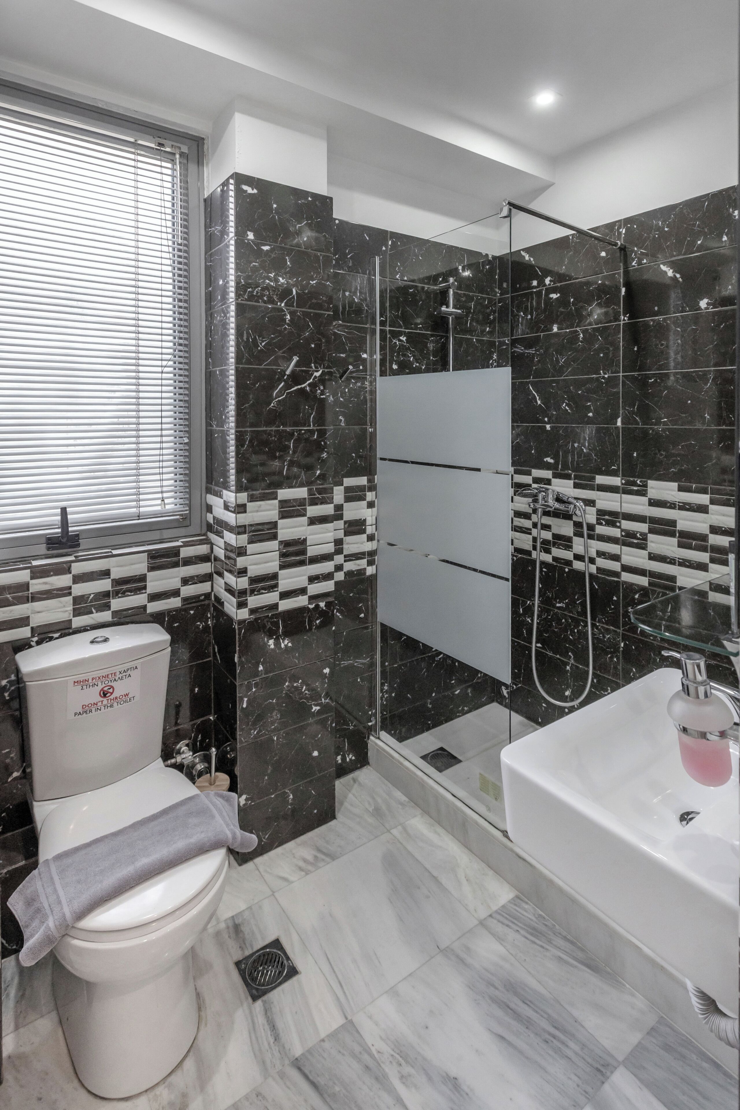 A modern bathroom with a toilet, sink, and shower area.
