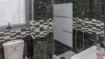 A modern bathroom with a toilet, sink, and shower area.