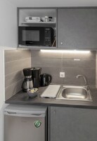 Suíte estúdio conforto, sacada, no piso térreo | Cozinha americana privada | Frigobar, micro-ondas, talheres/pratos/utensílios de cozinha