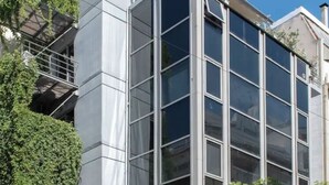Een modern gebouw met grote ramen en een metalen gevel.