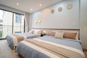 Habitación de hotel con dos camas, un balcón y vistas a la ciudad.