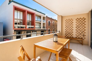 A balcony with a wooden table and chairs, a lantern, and a wooden lattice wall. - Luxury West End |heart of Freo | Parking (Fremantle)