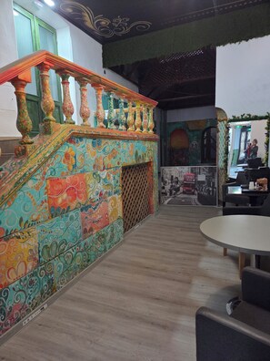 Eine Treppe mit farbenfrohen, verzierten Geländern und einer gemusterten Wand.