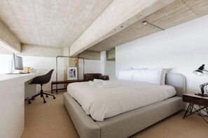 A modern bedroom with a large bed, a desk, a chair, and a bedside table. - Sunny 1BD Loft Style Flat in the Heart of Hackney (London)