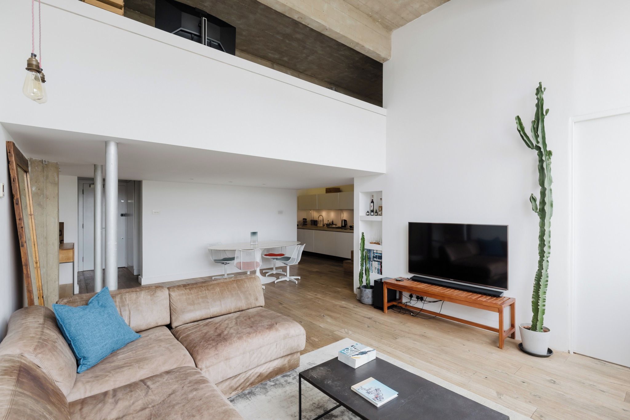 Un salon moderne avec un canapé, une table basse et un téléviseur à écran plat.